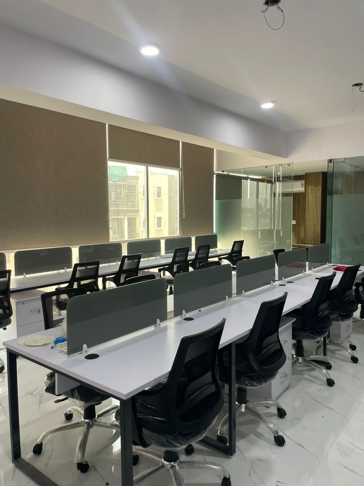 Shared desk workspace at Prozify Coworking Shyam Nagar Jaipur — white workstations with glass partitions